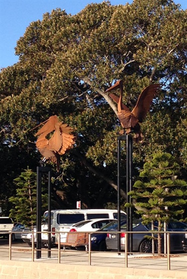 Folko Kooper, Pelicans. Lyne Park, Rose Bay. On loan courtesy of Michael and Judy McMahon. Tasmanian artist Folko Kooper has created two proud pelicans, paying homage to the birds who frequently enjoy the harbour area of Rose Bay. Perching high on their poles, the pelicans keep a watchful eye over the bay as well as enjoying the sea breeze through their feathers.