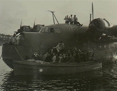 A group of civilians leaving the Short Sunderland aircraft and boarding a RAAF launch (RAAF 011-29) to be ferried back to the wharf at the Rose Bay flying boat base after being taken for a joy-flight. The aircraft, now captained by Flight Lieutenant (Flt Lt) Manger who had replaced Flt Lt M. S. Mainprize DFC, was making a tour of Australian states in support of the 3rd Victory Loan and, during each stop on the tour, took eligible subscribers of 100 pounds or more to the loan for a joy-flight. VIC1264 31 May 1945