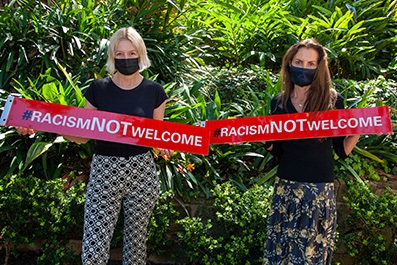 Councillor Luise Elsing and Mayor Susan Wynne with #RacismNotWelcome signs