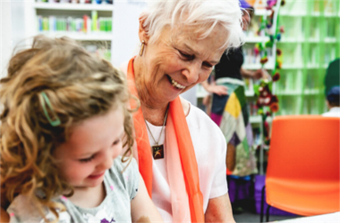 Grandmother and granddaughter enjoying a library program