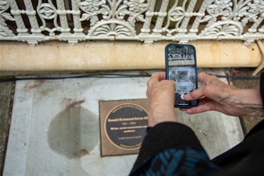 A guest photographs the plaque for Donald Horne.