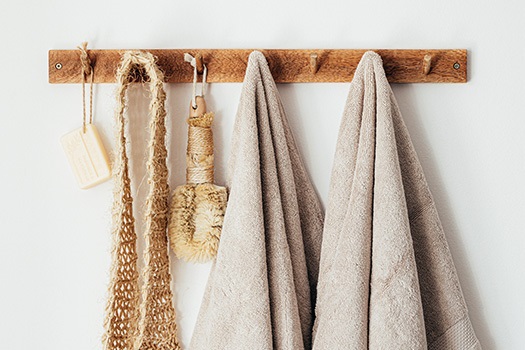 Plastic free bathroom products and towels hanging on a wooden rack