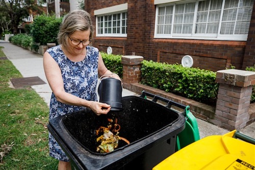 Female placing compost into bin