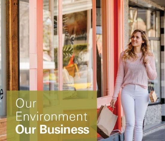 Woman looking at window display with shopping bag in her hand