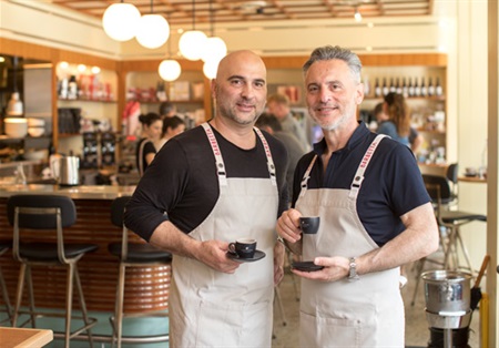 Two baristas at Barbetta holding coffee cups